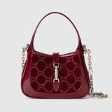 Red handbag with gold chain and clasp on a light gray background